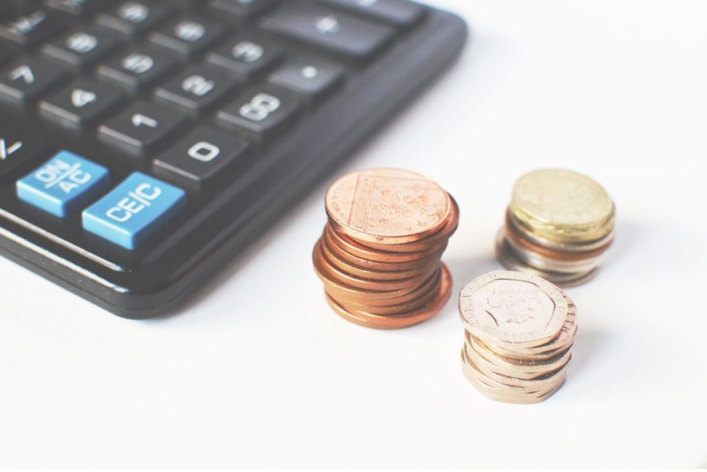 imagem com calculadora e moedas como inadimplência