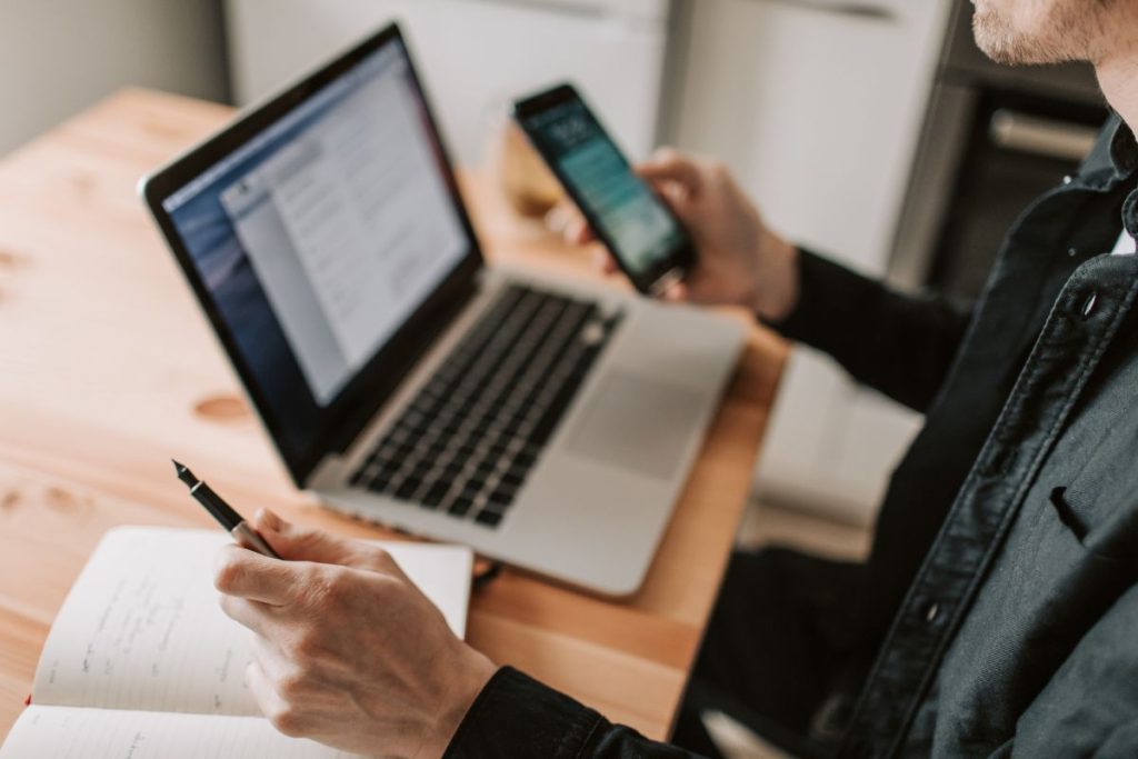 homem usando o WhatsApp Business pelo celular em casa